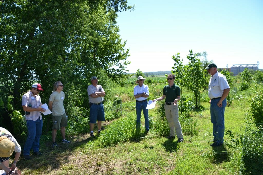 Lindsey Barney (speaking, second from right) of the Iowa DNR and Brad Riphagen (far right) of Trees Forever assisted Maggie and Steve with the riparian buffer.