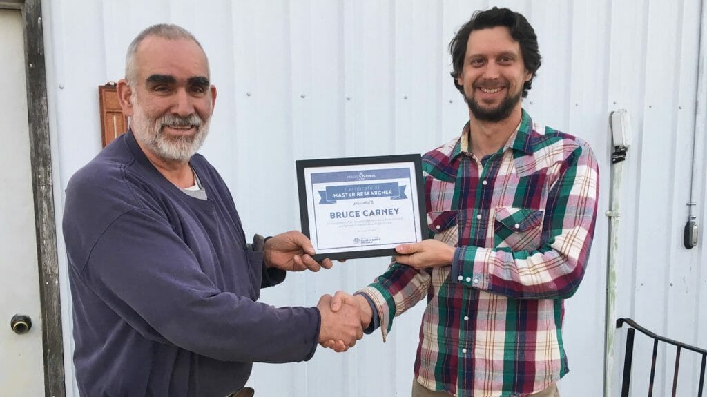 Bruce Carney, left, receiving 2019 Master Researcher Award from Stefan Gailans