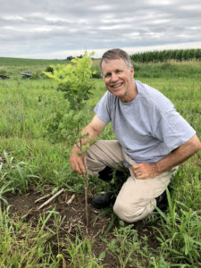 Gary Guthrie planting a tree.