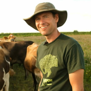 Torray Wilson standing with cows on his farm