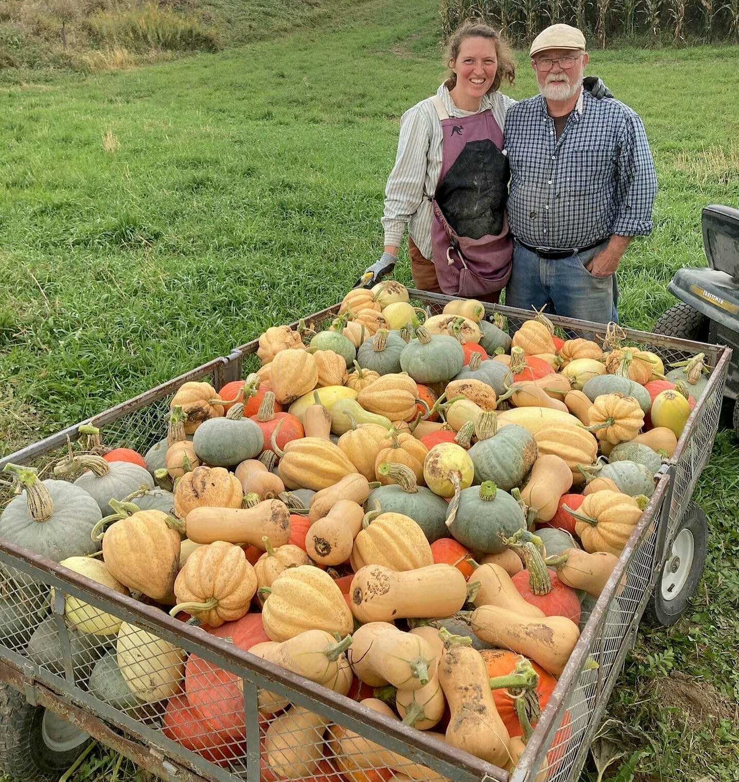 Natasha Hegmann and Paul Young pose with a wagon full of squash they grew for the Iowa Local Food Purchasing Assistance Program.