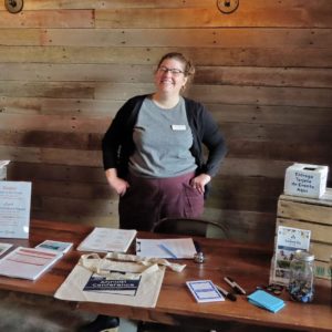 Rachel Burke at the welcome table for the 2024 Beginning Farmer Retreat.