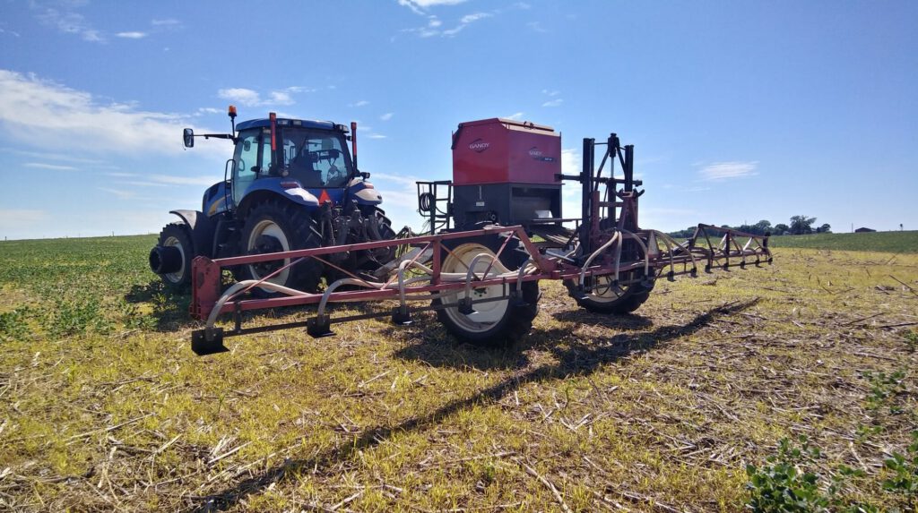 Tractor and seeder in soybean field.