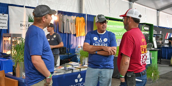 Farmers speaking with booth visitors at Farm Progress Show