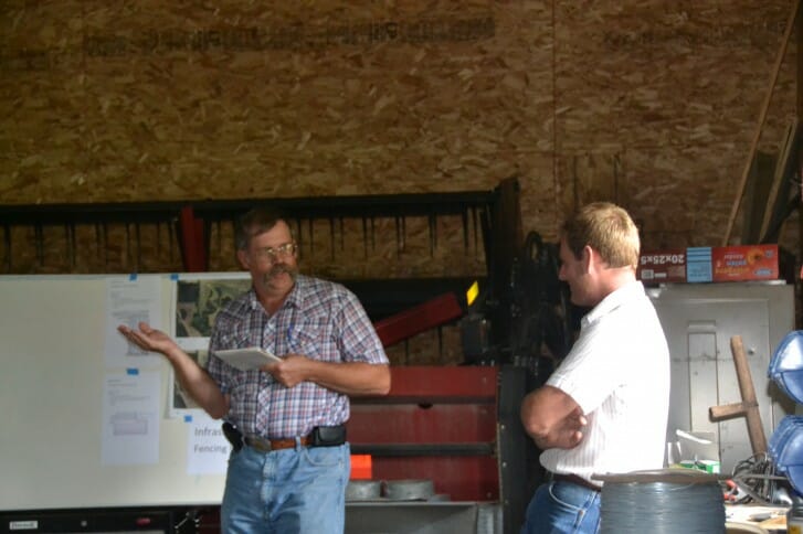 Wade Dooley discusses pasture fence options with a state conservationist.