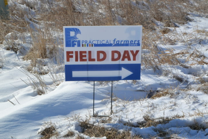 A Practical Farmers directional sign to the field day planted in a snow bank